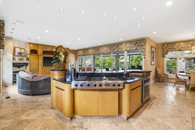 318 S Farm Rd Unit 193, Springfield, MO 65809 - kitchen featuring stainless steel gas stovetop, open floor plan, an island with sink, recessed lighting, and dark stone countertops