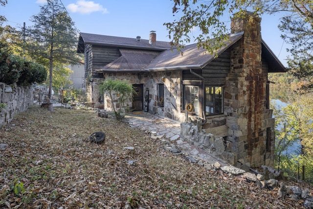 196 Lakeside Way, Forsyth, MO 65653 - rear view of house featuring a chimney, stone siding, and roof with shingles