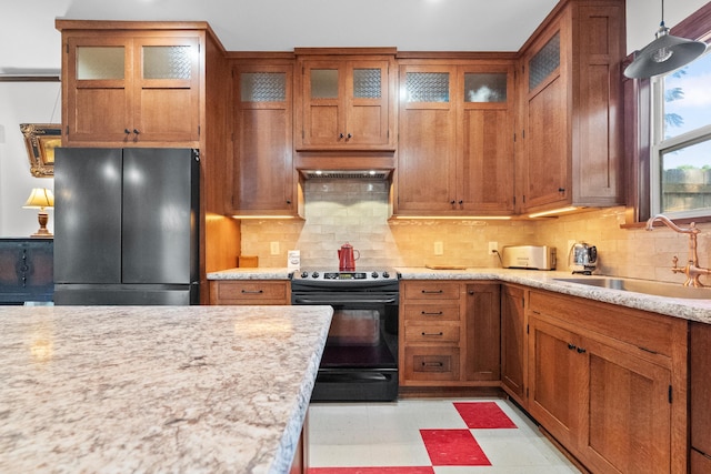 933 W Pershing St, Springfield, MO 65806 - kitchen featuring black appliances, brown cabinetry, light floors, and custom range hood