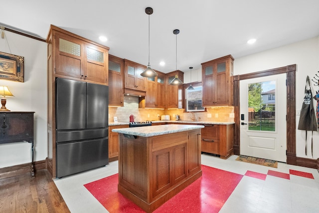 933 W Pershing St, Springfield, MO 65806 - kitchen with freestanding refrigerator, decorative backsplash, brown cabinetry, hanging light fixtures, and recessed lighting