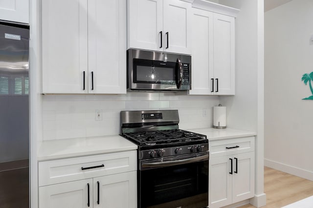 653 W Arbor Glenn Dr, Nixa, MO 65714 - kitchen featuring appliances with stainless steel finishes, decorative backsplash, light countertops, and white cabinetry