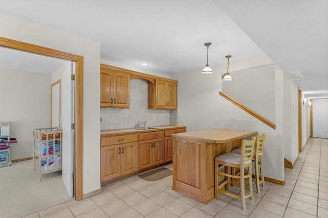 1190 E Headley St, Springfield, MO 65803 - kitchen featuring light countertops, tasteful backsplash, a breakfast bar area, pendant lighting, and light tile patterned flooring