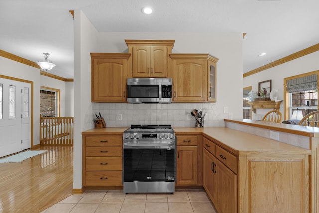 1190 E Headley St, Springfield, MO 65803 - kitchen with appliances with stainless steel finishes, light countertops, a peninsula, tasteful backsplash, and crown molding