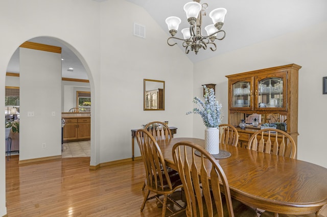 1190 E Headley St, Springfield, MO 65803 - dining room featuring a chandelier, arched walkways, light wood-style floors, plenty of natural light, and high vaulted ceiling