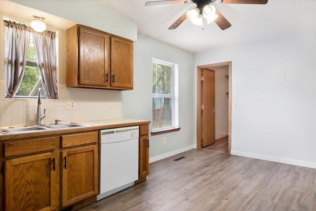 1219 N Clifton Ave, Springfield, MO 65802 - kitchen with white dishwasher, ceiling fan, light wood-type flooring, brown cabinetry, and a textured ceiling