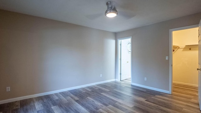 24 Oniatara Ln, Cherokee Village, AR 72529 - unfurnished bedroom with a spacious closet, dark wood-style flooring, a closet, and ceiling fan