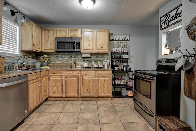 207 W Grand, Neosho, MO 64850 - kitchen with appliances with stainless steel finishes, light brown cabinetry, decorative backsplash, a textured ceiling, and light tile patterned flooring