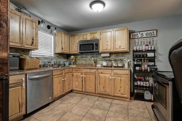 207 W Grand, Neosho, MO 64850 - kitchen with appliances with stainless steel finishes, a textured ceiling, backsplash, light tile patterned floors, and stone countertops