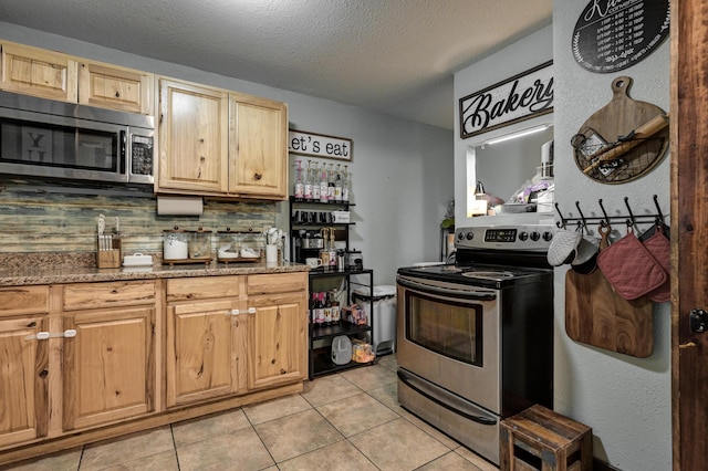 207 W Grand, Neosho, MO 64850 - kitchen featuring appliances with stainless steel finishes, light brown cabinets, light tile patterned flooring, tasteful backsplash, and a textured ceiling
