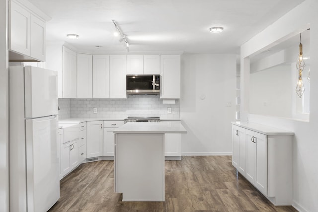 5295 E Farm Road 138, Springfield, MO 65809 - kitchen featuring freestanding refrigerator, stainless steel microwave, decorative backsplash, white cabinets, and light countertops