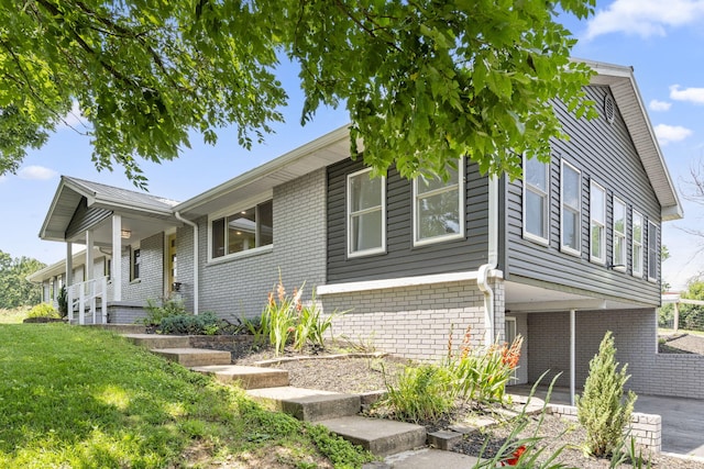 5295 E Farm Road 138, Springfield, MO 65809 - view of front facade with brick siding, covered porch, and a front yard