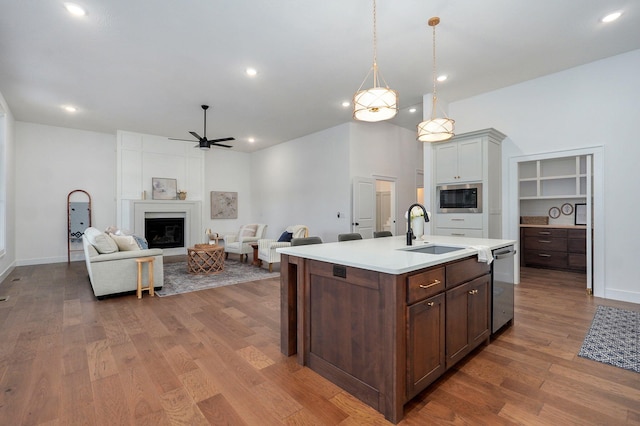 5030 E Swale Ct, Springfield, MO 65802 - kitchen featuring stainless steel appliances, ceiling fan, light countertops, wood finished floors, and an island with sink