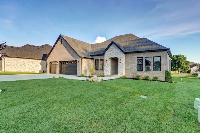 5030 E Swale Ct, Springfield, MO 65802 - french country inspired facade featuring an attached garage, a front yard, brick siding, concrete driveway, and roof with shingles