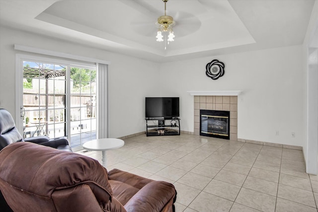 855 Birch St, Nixa, MO 65714 - living area featuring a raised ceiling, light tile patterned floors, a fireplace, and ceiling fan