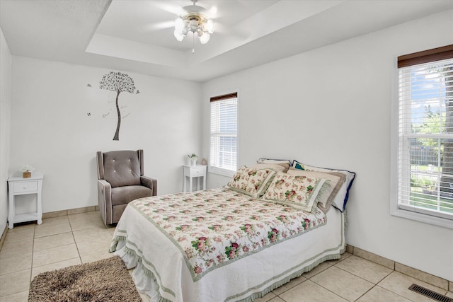 855 Birch St, Nixa, MO 65714 - bedroom featuring light tile patterned floors, multiple windows, and a tray ceiling