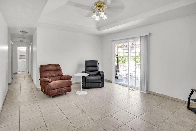 855 Birch St, Nixa, MO 65714 - living area featuring light tile patterned flooring, a ceiling fan, and a raised ceiling