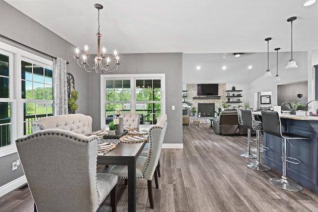 13030 County Lane 228, Oronogo, MO 64855 - dining space featuring healthy amount of natural light, a chandelier, lofted ceiling, dark wood-style floors, and a stone fireplace