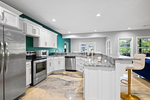 13030 County Lane 228, Oronogo, MO 64855 - kitchen with stainless steel appliances, recessed lighting, a kitchen breakfast bar, plenty of natural light, and white cabinetry