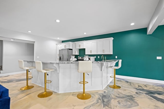 13030 County Lane 228, Oronogo, MO 64855 - kitchen with appliances with stainless steel finishes, a kitchen bar, white cabinetry, recessed lighting, and light stone countertops