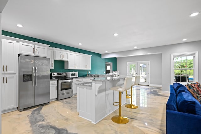 13030 County Lane 228, Oronogo, MO 64855 - kitchen featuring appliances with stainless steel finishes, open floor plan, a kitchen bar, recessed lighting, and white cabinetry