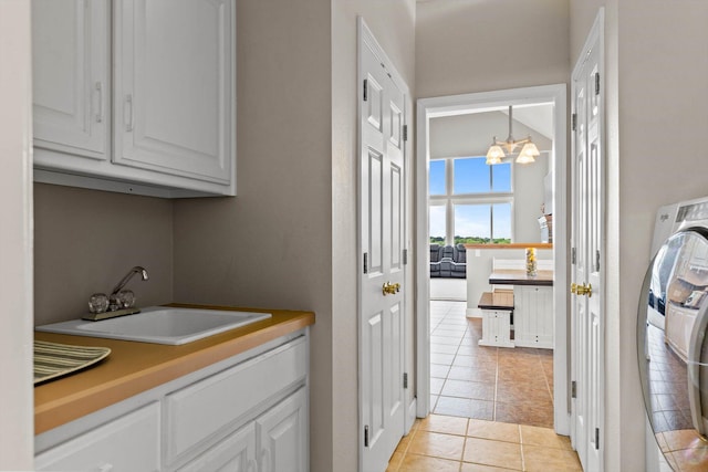 4201 N Farm Rd Unit 205, Strafford, MO 65757 - washroom featuring cabinet space, light tile patterned floors, a chandelier, and washer / clothes dryer