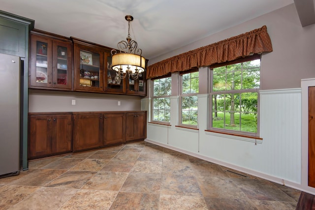 5795 S Wedgewood Ave, Springfield, MO 65810 - unfurnished dining area with a chandelier and light stone finish flooring