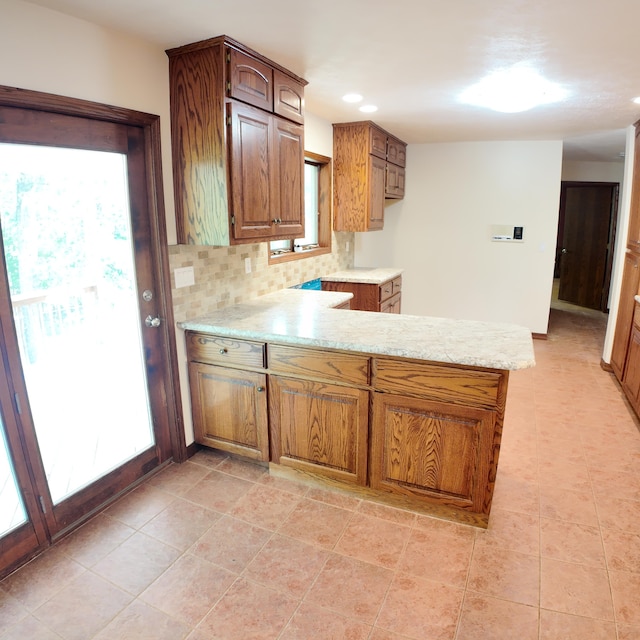 3352 W State Highway 76, Cape Fair, MO 65624 - kitchen featuring a peninsula, decorative backsplash, light stone countertops, brown cabinets, and recessed lighting