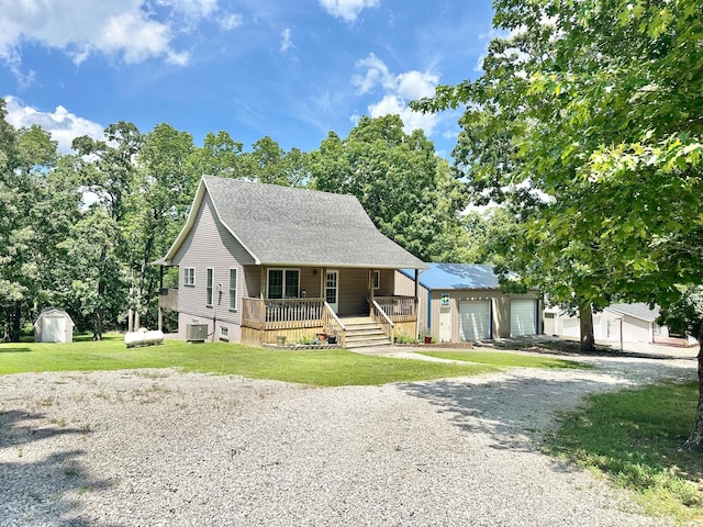 26569 County Road 225, Flemington, MO 65650 - view of front of home with a porch, an outdoor structure, a garage, a front lawn, and a shingled roof