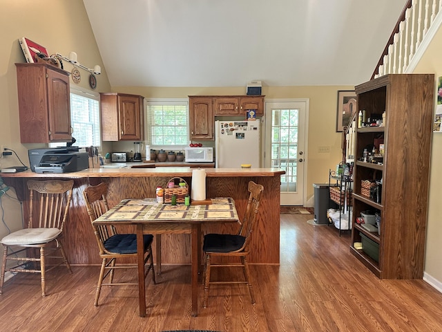 26569 County Road 225, Flemington, MO 65650 - kitchen featuring white appliances, vaulted ceiling, a peninsula, dark wood-type flooring, and light countertops