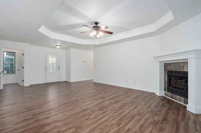 2000 E Greenwich Dr, Ozark, MO 65721 - unfurnished living room with a raised ceiling, a ceiling fan, dark wood-type flooring, and a tiled fireplace