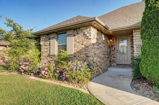 2000 E Greenwich Dr, Ozark, MO 65721 - view of exterior entry featuring a shingled roof, brick siding, and stone siding