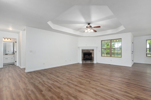 2000 E Greenwich Dr, Ozark, MO 65721 - unfurnished living room with a raised ceiling, wood finished floors, a ceiling fan, and a tiled fireplace