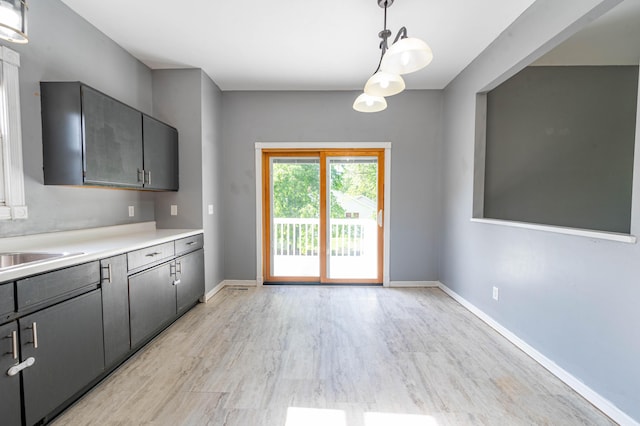 4147 E Kellis Ct, Springfield, MO 65802 - kitchen featuring light wood-type flooring, light countertops, gray cabinets, and hanging light fixtures
