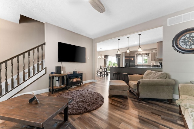 2505 Talking Rocks Rd, Branson West, MO 65737 - living area featuring wood finished floors, a chandelier, a wood stove, and stairs