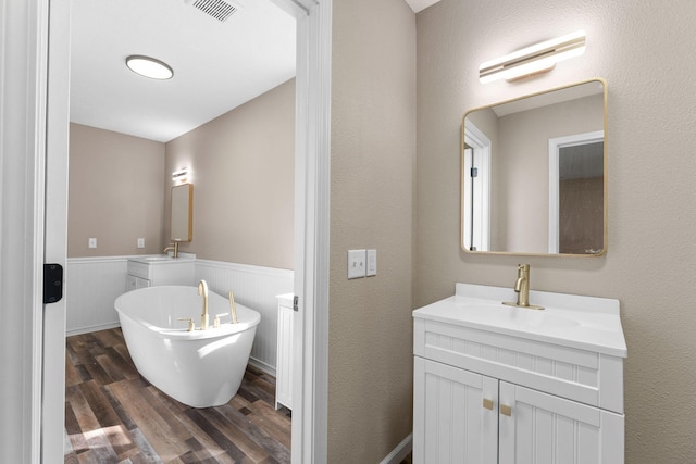2505 Talking Rocks Rd, Branson West, MO 65737 - bathroom featuring wood finished floors, a freestanding bath, vanity, and wainscoting