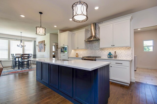 1604 N Bristol Ave, Springfield, MO 65802 - kitchen featuring wall chimney exhaust hood, backsplash, light countertops, dark wood-style flooring, and white cabinets