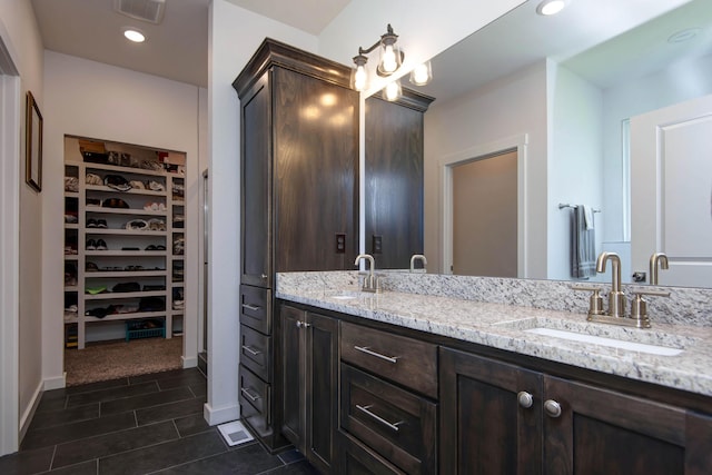 1604 N Bristol Ave, Springfield, MO 65802 - bathroom featuring double vanity, a walk in closet, recessed lighting, and tile patterned floors
