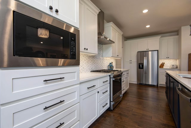 1604 N Bristol Ave, Springfield, MO 65802 - kitchen with appliances with stainless steel finishes, wall chimney range hood, light countertops, dark wood-style flooring, and recessed lighting