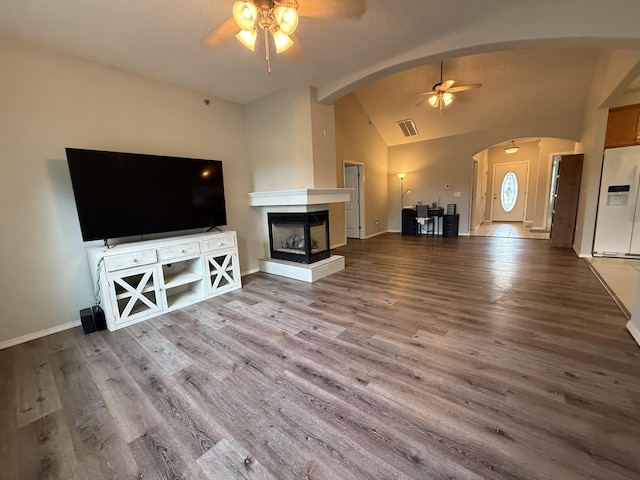 1352 N Sandy Creek Cir Unit 3, Nixa, MO 65714 - unfurnished living room featuring ceiling fan, arched walkways, vaulted ceiling, wood finished floors, and a multi sided fireplace