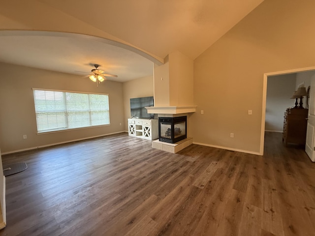 1352 N Sandy Creek Cir Unit 3, Nixa, MO 65714 - unfurnished living room featuring ceiling fan, arched walkways, dark wood finished floors, a multi sided fireplace, and high vaulted ceiling