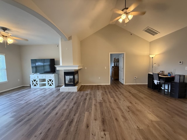 1352 N Sandy Creek Cir Unit 3, Nixa, MO 65714 - unfurnished living room featuring a ceiling fan, wood finished floors, vaulted ceiling, a multi sided fireplace, and arched walkways