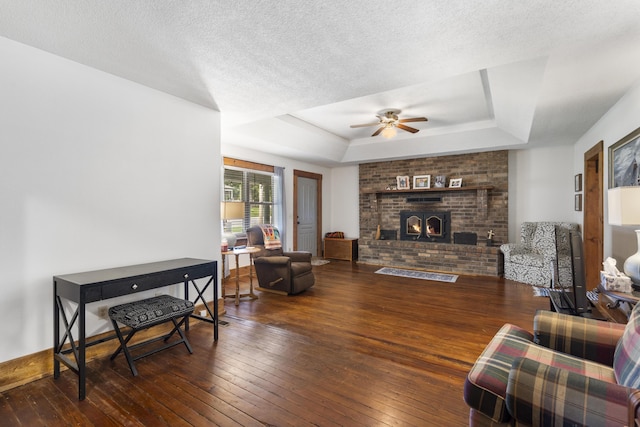 400 E Walker St, Ash Grove, MO 65604 - living area with a tray ceiling, ceiling fan, hardwood / wood-style floors, a fireplace, and a textured ceiling