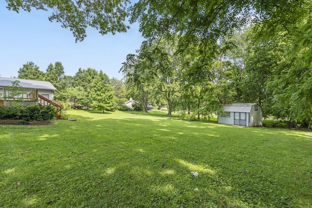 400 E Walker St, Ash Grove, MO 65604 - view of grassy yard featuring a storage shed and a deck