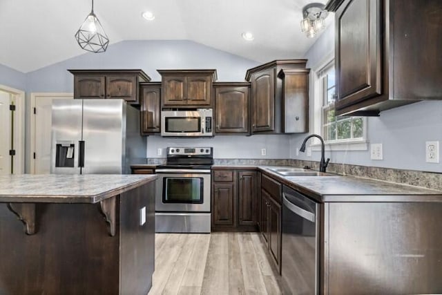 223 Roundhill Rd, Branson, MO 65616 - kitchen with appliances with stainless steel finishes, dark brown cabinets, light wood-style flooring, lofted ceiling, and decorative light fixtures