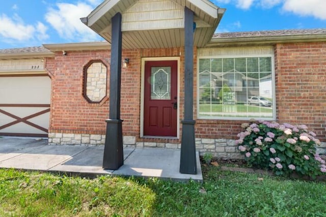 223 Roundhill Rd, Branson, MO 65616 - property entrance featuring a garage and brick siding