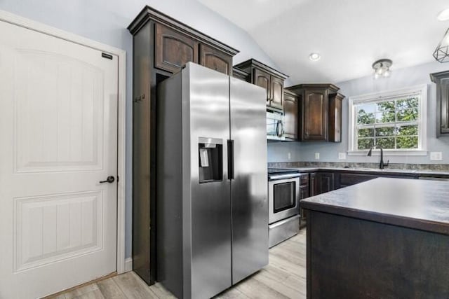 223 Roundhill Rd, Branson, MO 65616 - kitchen featuring appliances with stainless steel finishes, dark brown cabinets, lofted ceiling, light wood-type flooring, and dark countertops