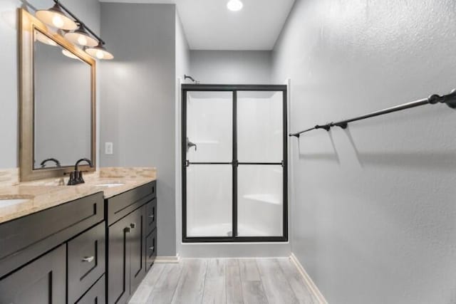 223 Roundhill Rd, Branson, MO 65616 - bathroom featuring wood finished floors, a stall shower, double vanity, and recessed lighting