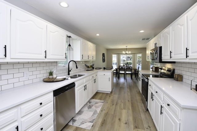 3457 S Barnes Ave, Springfield, MO 65804 - kitchen featuring appliances with stainless steel finishes, backsplash, a chandelier, white cabinetry, and recessed lighting
