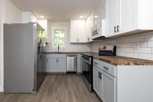1830 N Hillcrest Ave, Springfield, MO 65802 - kitchen with appliances with stainless steel finishes, butcher block countertops, wood finished floors, white cabinetry, and recessed lighting