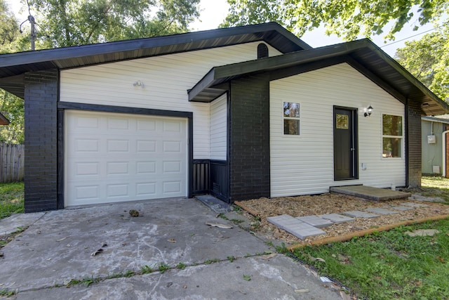 1830 N Hillcrest Ave, Springfield, MO 65802 - view of front of property featuring concrete driveway, brick siding, and a garage
